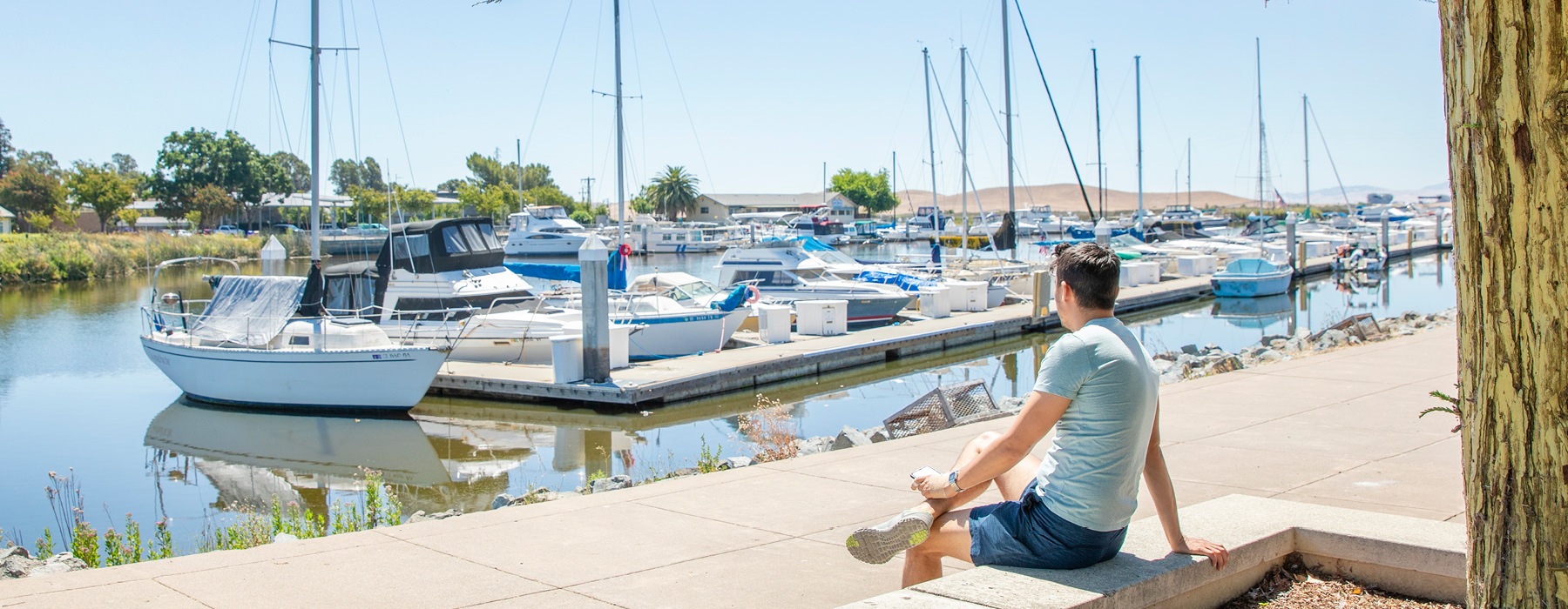 Man sitting in the sun by the water